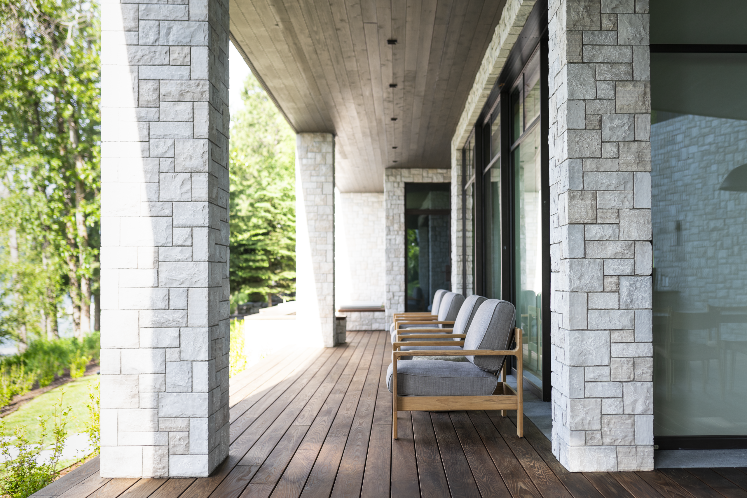 Exterioir sitting area surrounded by custom masonry and stone work on exotic decking. Montana Lakehouse.